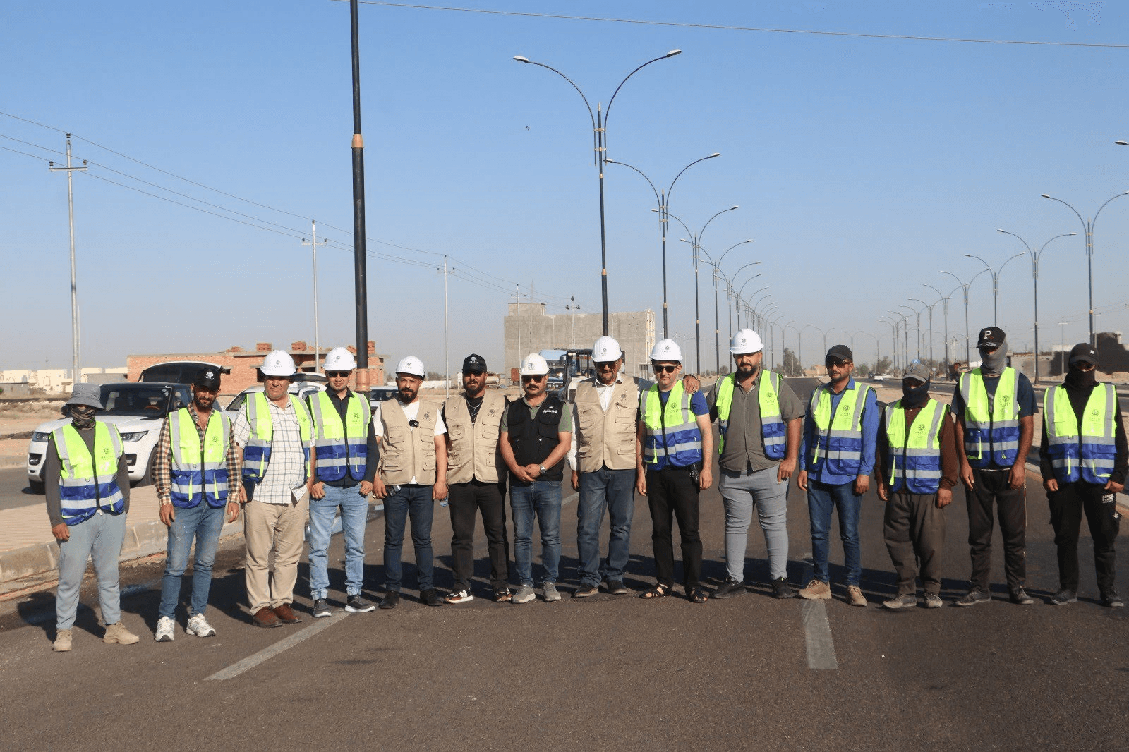 Project and site team standing on the completed Ameriyat Al-Sumood highway in Al Anbar